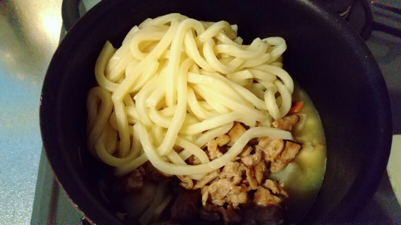 だし汁で煮込んだ野菜・肉・うどんを一緒にしてひと煮立ちさせる